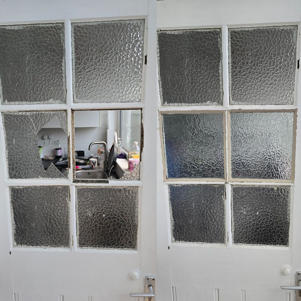 Broken door glass panel being dealt with