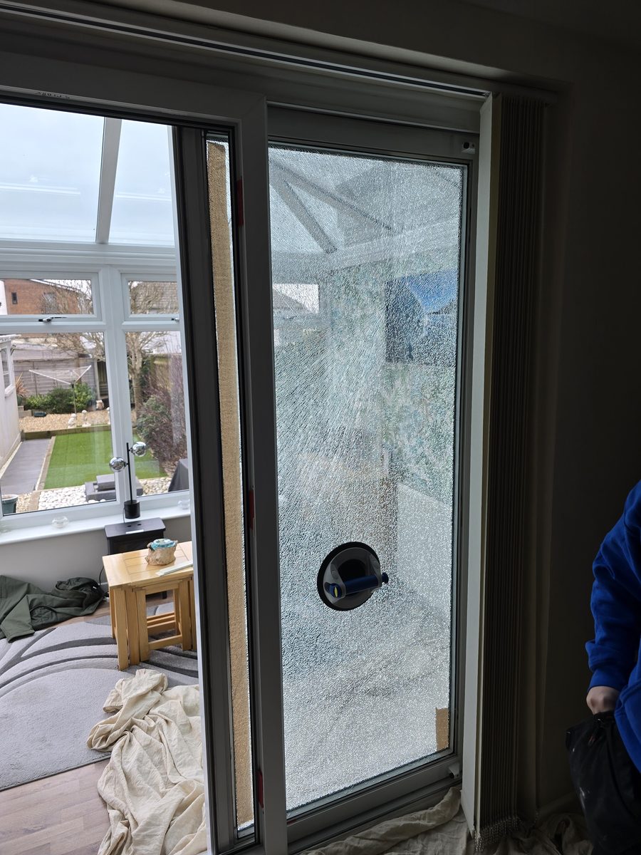Smashed patio door glass being removed