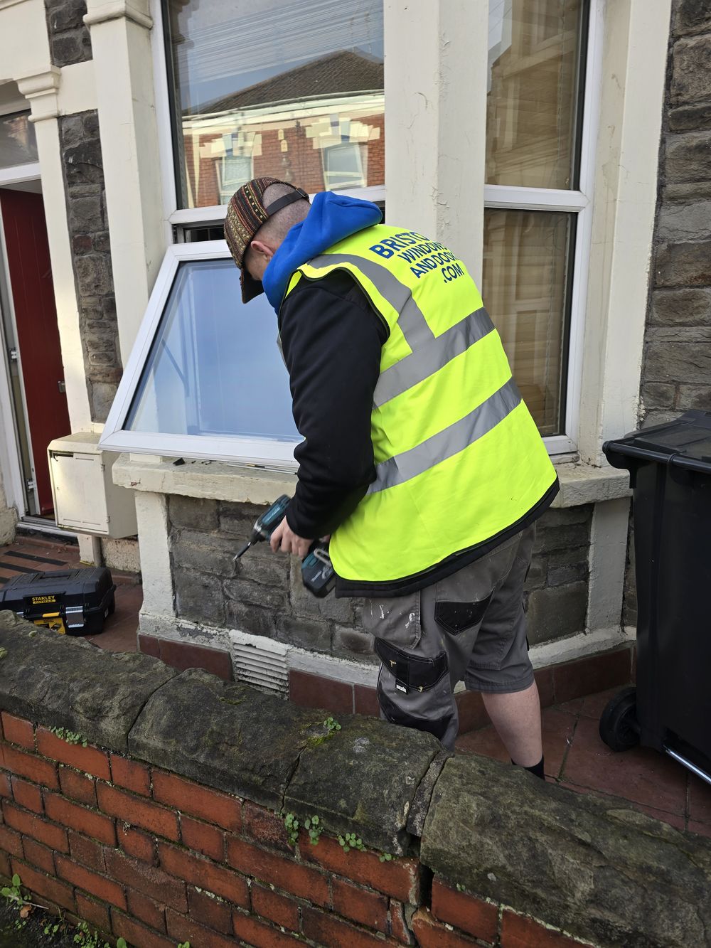 Technician repairing a window lock on the exterior of a Bristol home