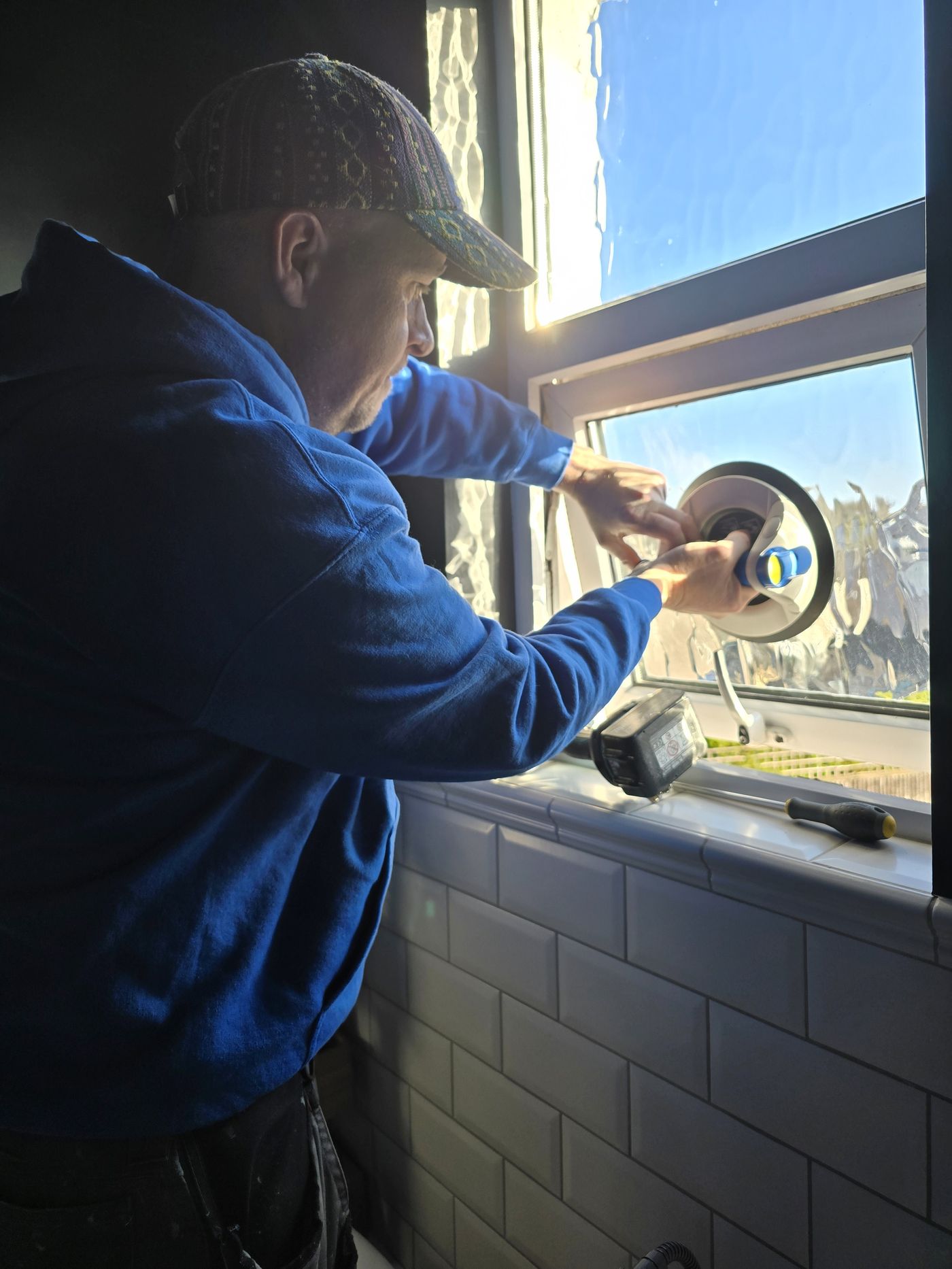 Technician using suction tool during window glass work